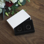 wedding rings with flowers on wooden table 2026 03 17 08 59 00 utc
