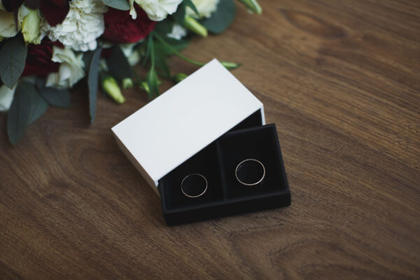 wedding rings with flowers on wooden table 2026 03 17 08 59 00 utc