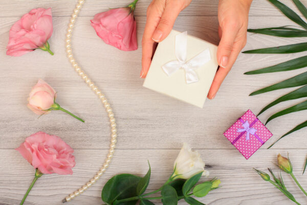 woman s hands holding a gift box on gray wooden ba 2026 03 26 07 18 57 utc