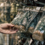 woman s hand holding christmas ornaments in store 2026 03 16 23 00 51 utc